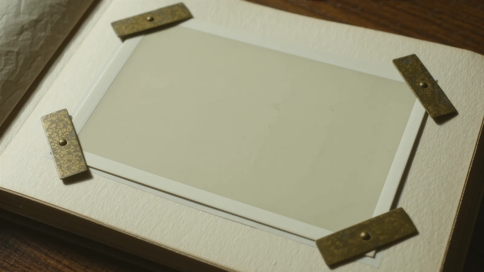 A brass loupe on a stack of ivory prints