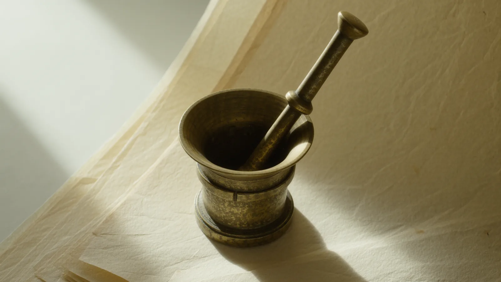 Mörser und Stößel aus Messing auf heller Fläche